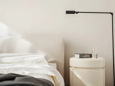 A minimalist bedroom featuring a bed and lamp beside it.