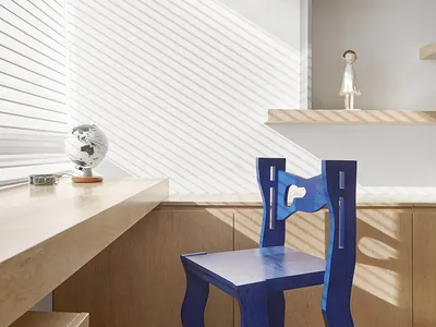 A modern home office featuring a blue chair with a unique, wavy design and a wooden desk and shelves.