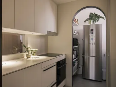 A modern kitchen with minimalist design and white cabinets.