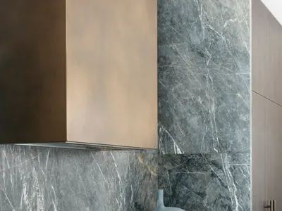 A modern kitchen with marble countertops and backsplash, featuring dark wooden cabinets and stainless steel appliances.