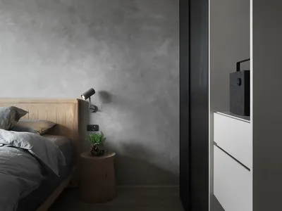 A minimalist bedroom with concrete walls and wooden furniture.