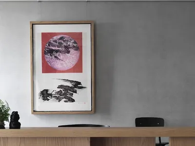現代辦公室內擺放木質書桌與黑色椅子，並掛有抽象畫作。