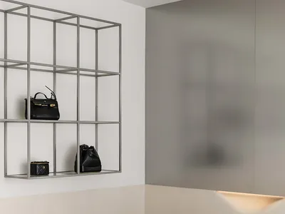 A minimalist bedroom featuring metal-frame shelves, wooden floor, and marble tabletop.