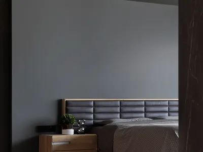 A minimalist bedroom featuring a wooden nightstand, a leather upholstered bed, and a textured blanket.