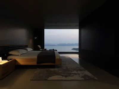 簡約臥室內設有木質床架、地毯，以及寧靜水景的窗外景色。