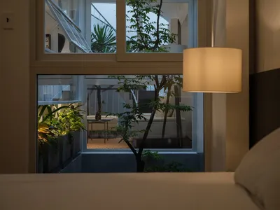 一間現代臥室，搭配質感壁紙與植栽。