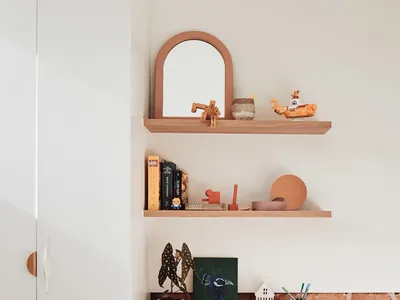 A minimalist home office setup featuring a wooden desk, a white chair, and a brick wall backdrop.