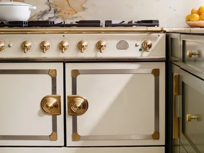 A modern kitchen featuring marble countertops and brass hardware