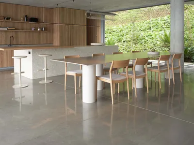 A minimalist residential kitchen with concrete flooring and minimalistic furniture.