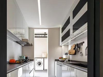 A minimalist kitchen with white cabinets and countertops.
