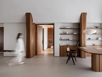A modern home office featuring wooden furniture and shelves.