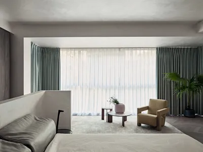 A minimalist bedroom featuring curtains, hardwood flooring, and a tranquil color palette.