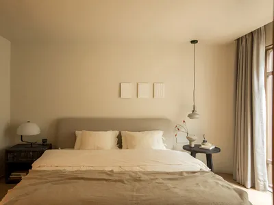 A minimalist bedroom with neutral tones and simple decor.