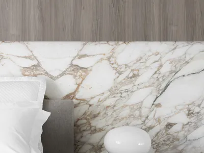 Minimalist bedroom featuring a grey upholstered headboard and white marble accents.