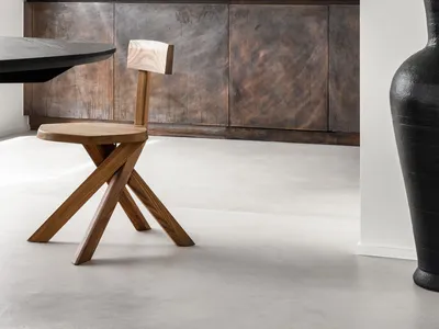 A modern kitchen with metallic wood cabinets and a black table with a wooden stool.