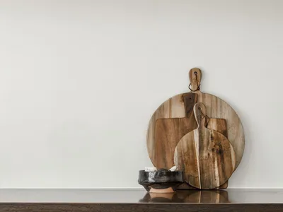 A modern kitchen with a wooden board on a dark, textured countertop.