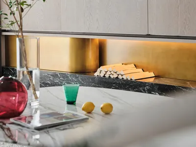 Modern kitchen interior featuring marble countertops and wooden cabinets.