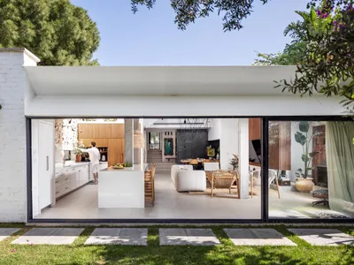 A modern living, dining, and kitchen space with open layout and white tile floor.