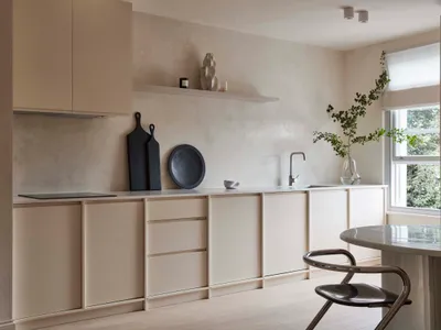 A modern minimalist kitchen with ceramic and concrete finishes, featuring sleek cabinets and a clean open layout.