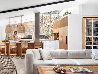 A modern living room and kitchen with concrete and wooden elements