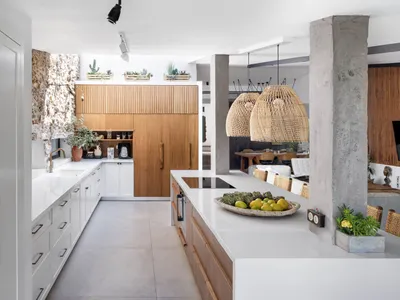A modern minimalist kitchen with concrete and white finishes, featuring a large window