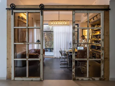 A home office featuring industrial design elements with glass and wood sliding doors.