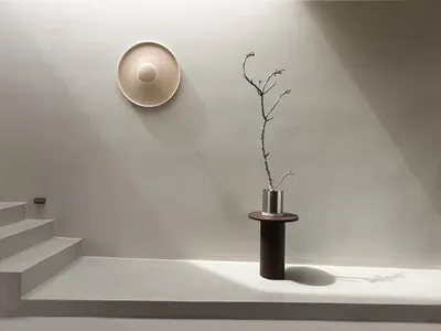 A minimalist living room with concrete elements and a single plant.