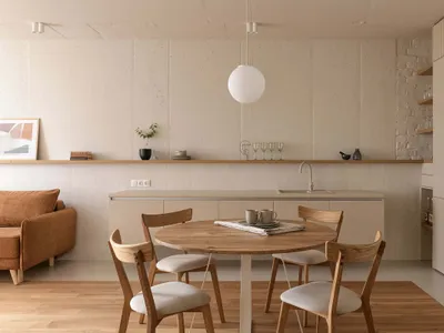 Photograph of a minimalist residential kitchen with wood furniture, concrete backsplash, and laminate countertop.