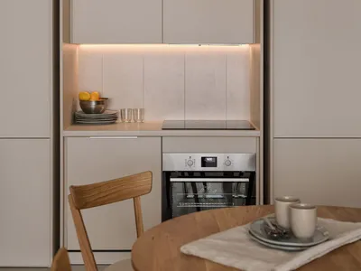A modern minimalist kitchen featuring concrete countertops and backsplash.