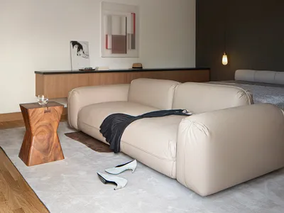 A modern minimalist bedroom with a grey sofa, minimalist decor, and a simple color palette.