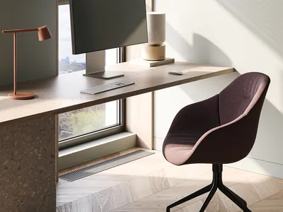 A minimalist home office featuring a wooden desk with a computer setup, a comfortable chair, and a sleek lamp.