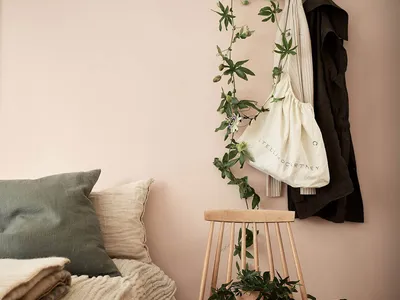 A minimalist bedroom featuring wooden furniture, cloth bedding, and a floral decoration.