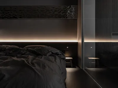 A minimalist bedroom with dark fabric bedding and warm ambient lighting.