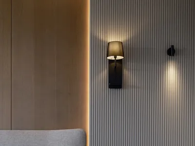A modern bedroom with a wooden texture featuring wall-mounted lamps and a floating nightstand.