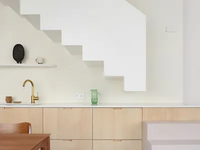 A modern kitchen featuring wooden cabinets and concrete flooring.