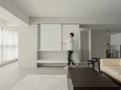 A minimalist living room featuring a concrete floor and furniture.