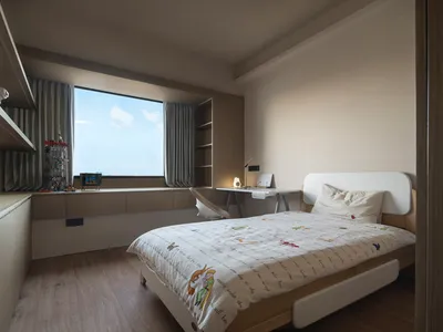 Modern minimalist bedroom with a wooden bed and window overlooking blue sky.