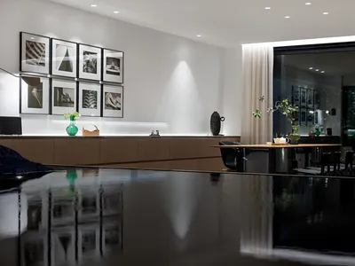現代簡約風格的廚房與餐廳，搭配流線黑桌椅、白牆與自然採光。