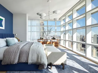 Modern minimalist bedroom with gray and glass elements.