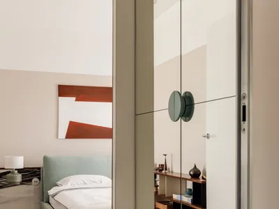 A modern minimalist bedroom featuring neutral tones and simple design.