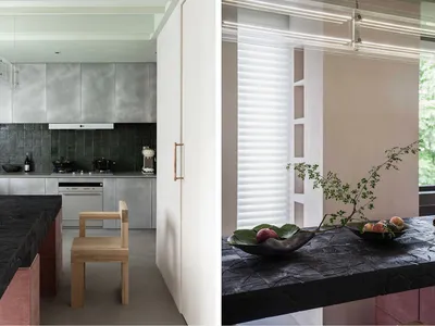 A minimalist kitchen with metallic cabinets and wooden seating.