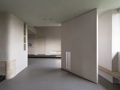 A minimalist kitchen featuring concrete walls and flooring.