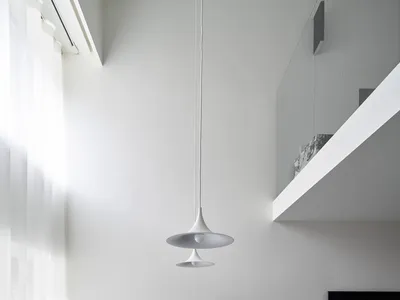 Modern minimalist kitchen with black marble countertop and white pendant lights.