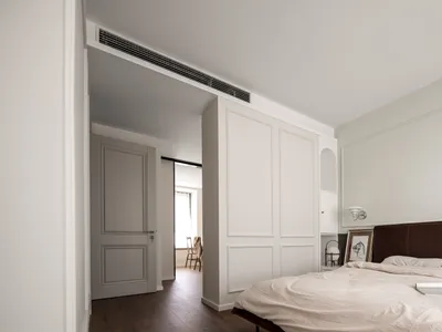 Minimalist bedroom with modern white furniture and materials.