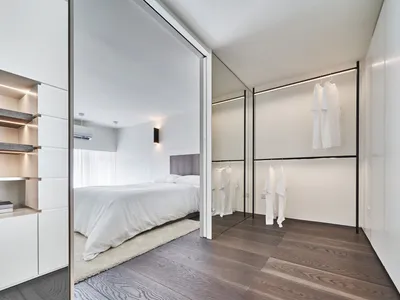 Modern bathroom with white walls, wood flooring, and minimalist design.