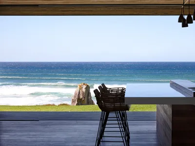 Modern kitchen with ocean view, featuring wood materials and sleek design.