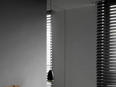 A modern minimalist bedroom with monochrome color palette, featuring a bed with a wooden headboard, gray bedding, a dark meta