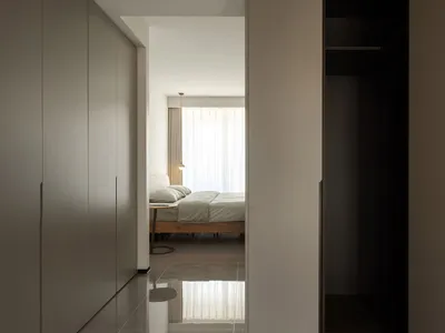 一間擁有白色牆面與簡約床鋪的現代簡約臥室。