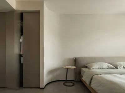 Minimalist bedroom with a neutral color palette and simple, uncluttered decor.