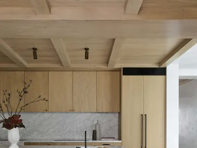 A modern kitchen featuring marble countertops and wooden cabinets.
